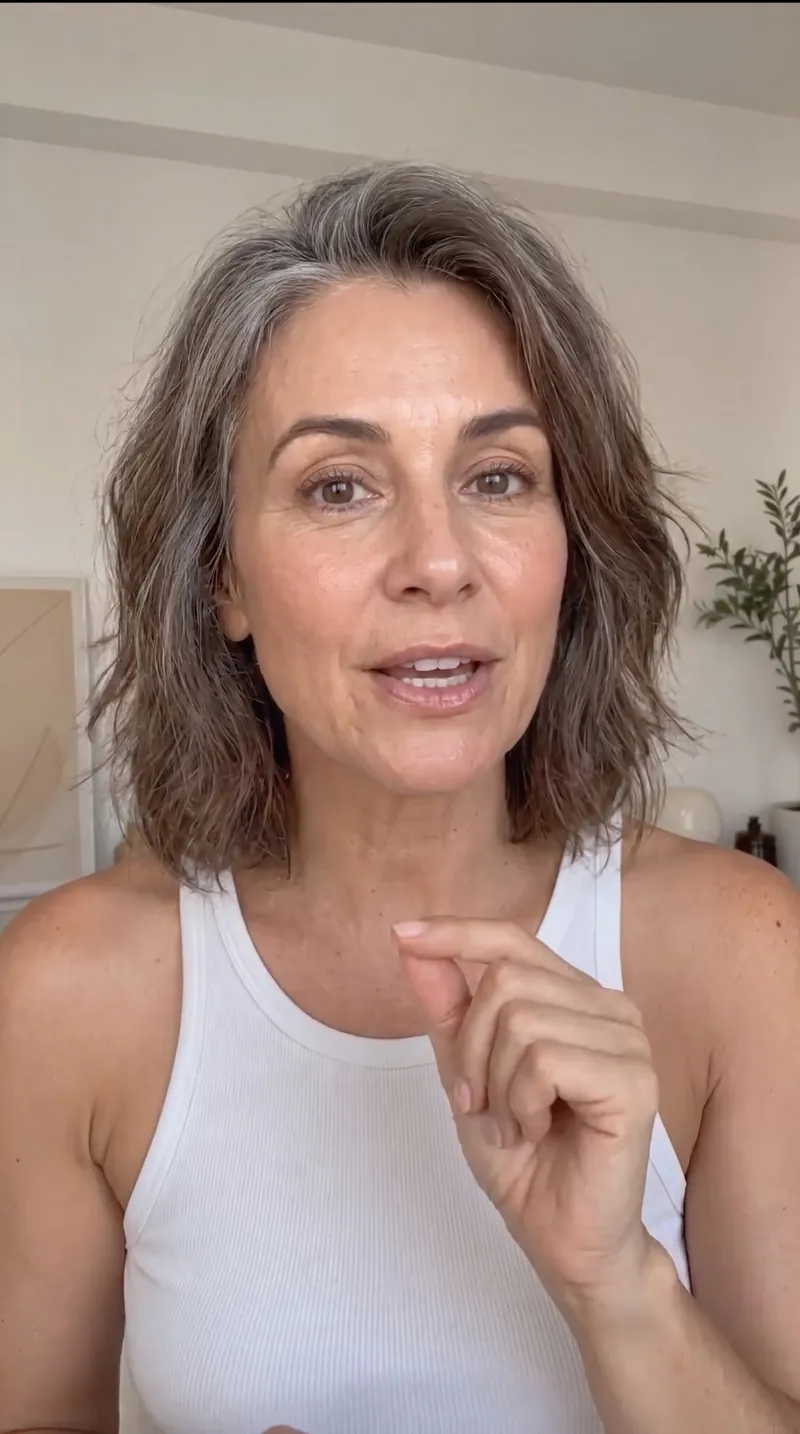 Immagine fatta con Nano Banana Pro: selfie stile UGC di una donna sui 50 anni con capelli grigi che parla in camera a casa